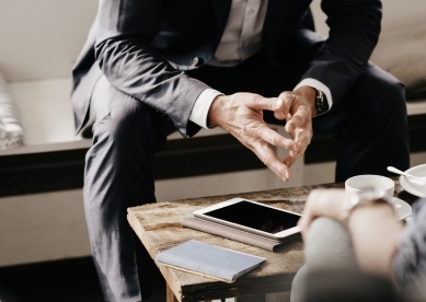 Advisor with hands together talking to client